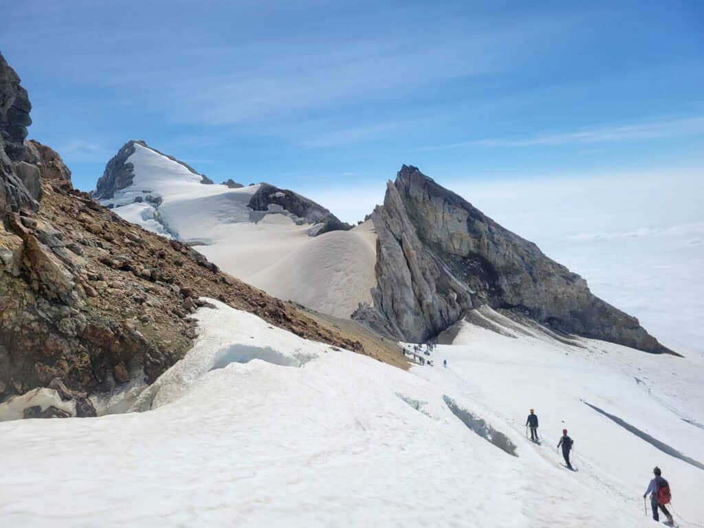 Climbers descending back to the crater rim on the Easton Glacier. Sherman Peak is in the background.