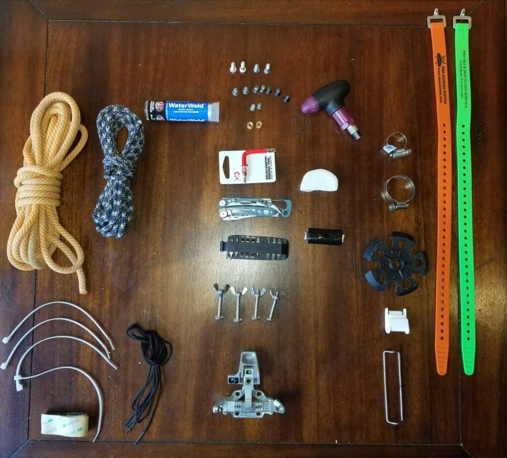 Gear repair kit with an assortment of tools, screws, and binding materials